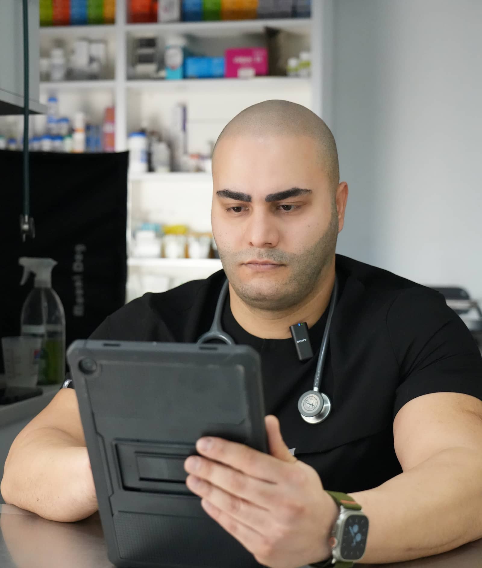 Dr. Omid Mavedati, a trusted veterinarian in Vancouver, reviewing a pet's medical records on a tablet in the clinic.